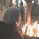 Mujer encendido velas en la iglesia del Santo Sepulcro