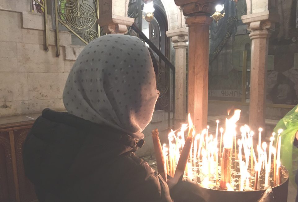 Mujer encendido velas en la iglesia del Santo Sepulcro
