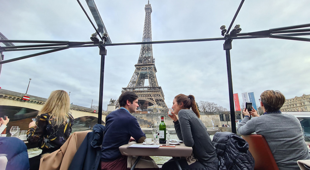 Pareja con cena romántica frente a la Torre Eiffel